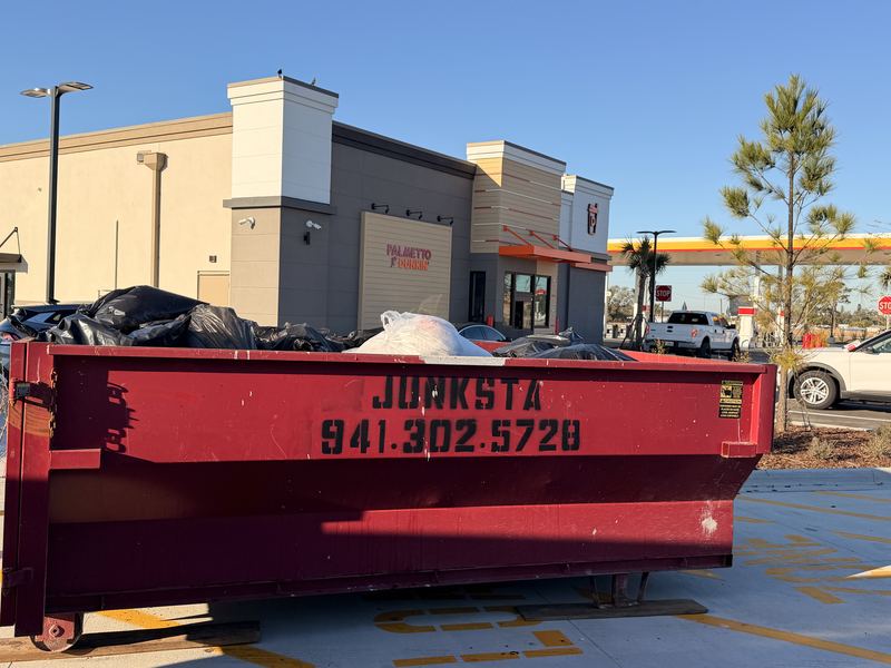 Branded Junksta dumpster on a commercial job site