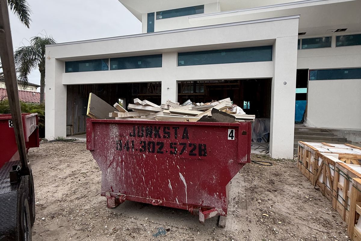 Red Junksta roll-off dumpster delivered in Anna Maria, FL