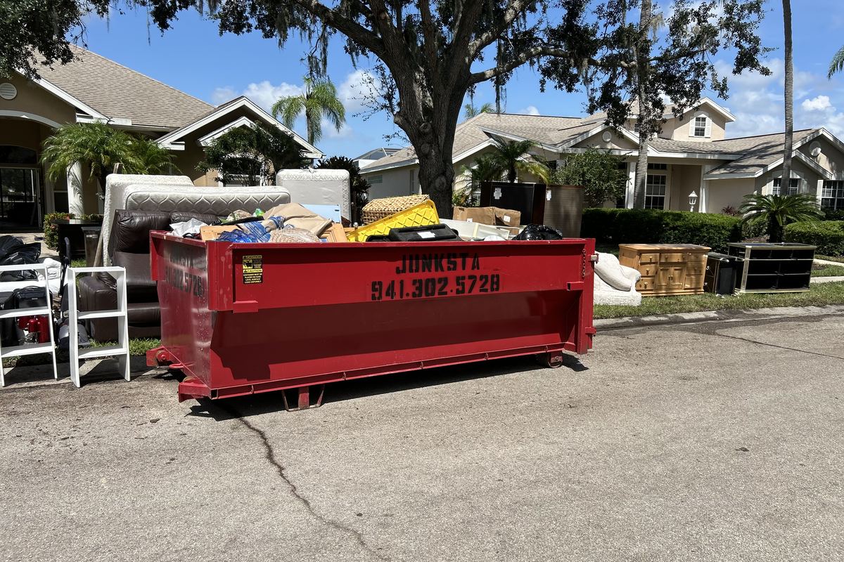 Red Junksta roll-off dumpster delivered in Arcadia, FL