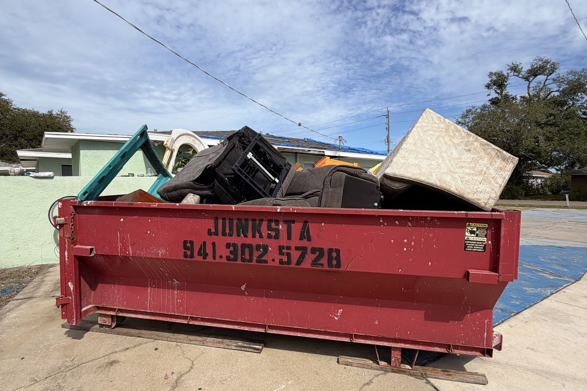 Red Junksta roll-off dumpster delivered in Bradenton Beach, FL