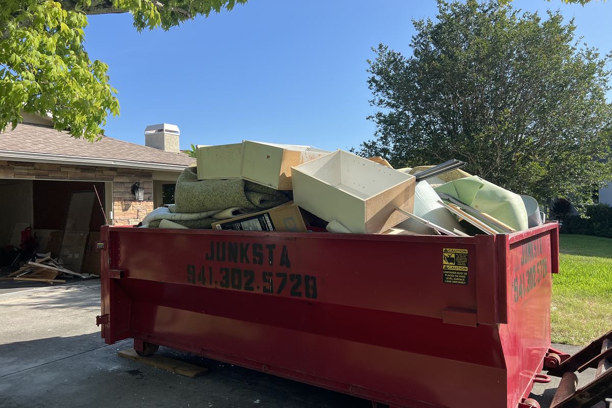 Red Junksta roll-off dumpster delivered in Myakka City, FL